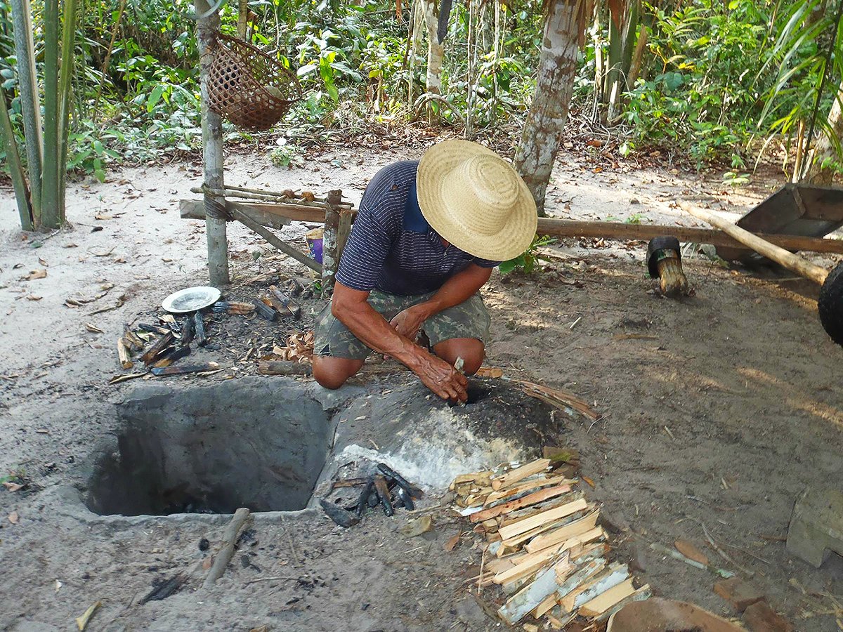 A caboclo (Amazon dweller) preparing an oven to manufacture rubber