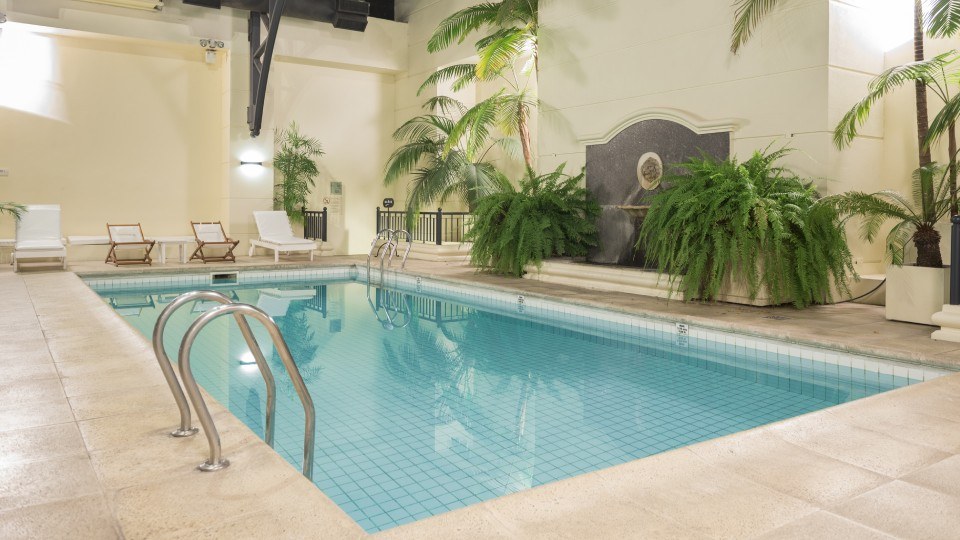 Heated pool at Loi Suites Recoleta surrounded by greenery